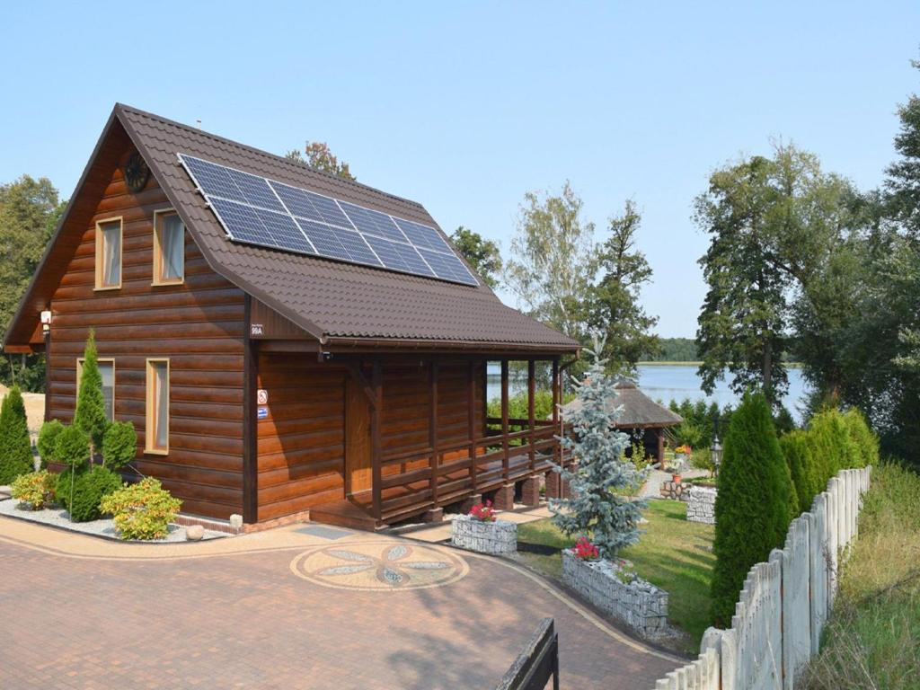 una casa con paneles solares en el techo en A luxury home on the shore of the lake Living room with fireplace 2 bedrooms, en Lubrza