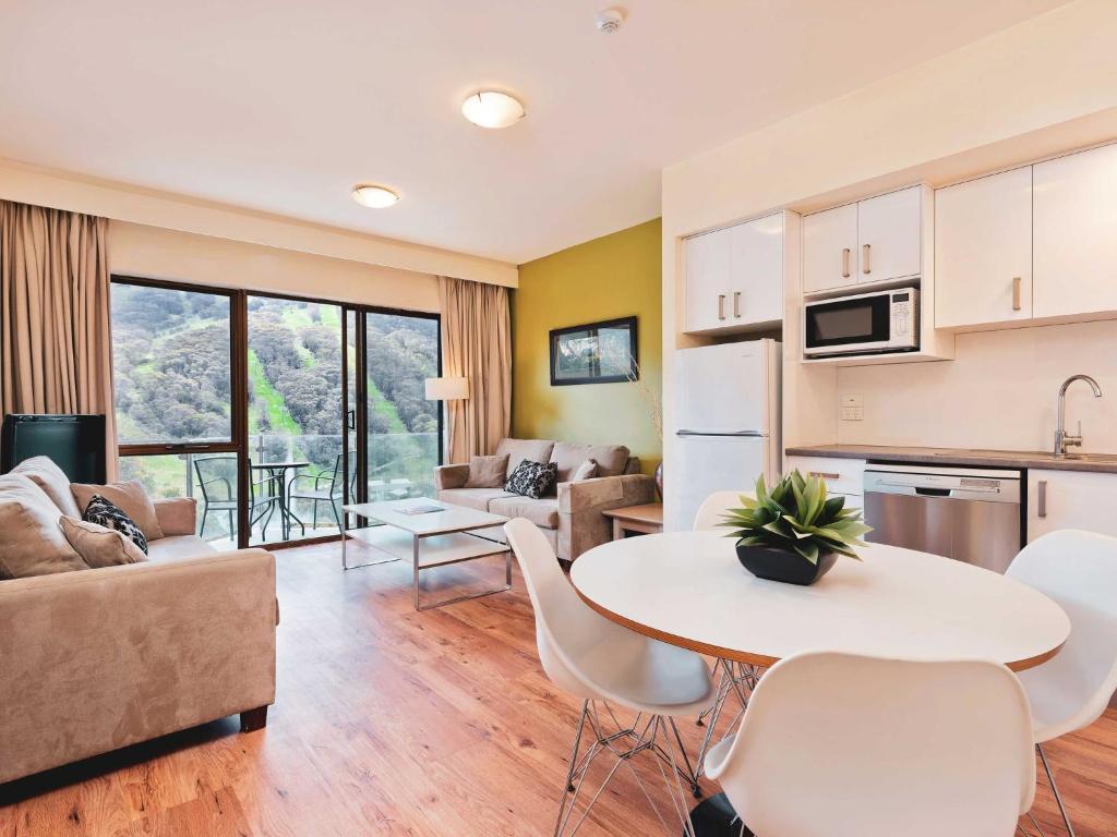 a kitchen and living room with a table and chairs at Lantern 1 Bedroom Balcony with spectacular view in Thredbo