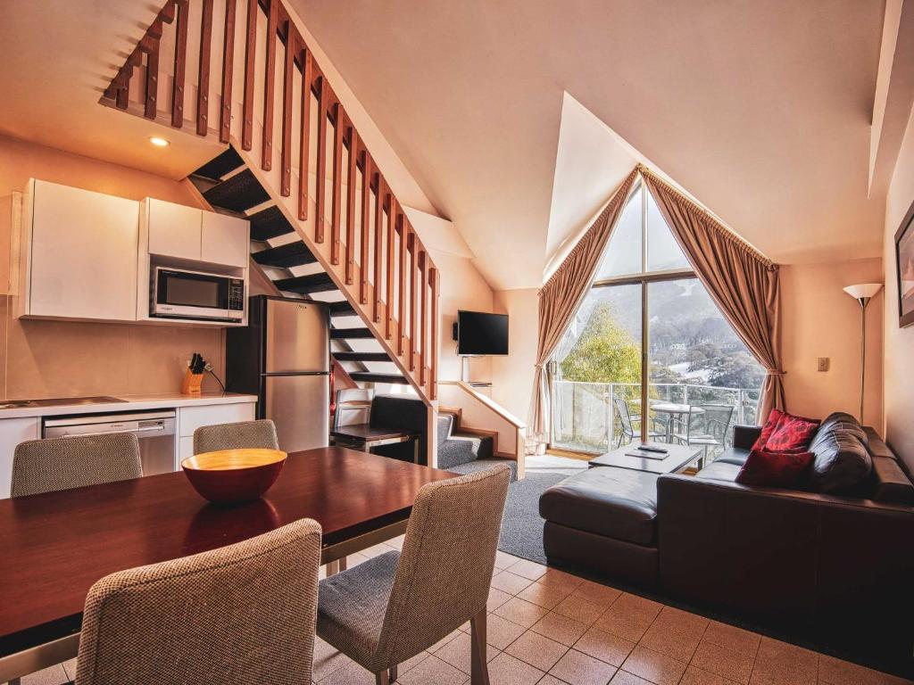 a kitchen and living room with a table and a couch at Lantern 1 Bedroom Loft with car space and Majestic View in Thredbo