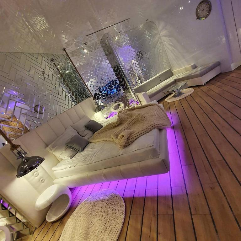 a white couch in a room with purple lights at Hotel Ramka & Restaurant & Wine Bar in Poznań