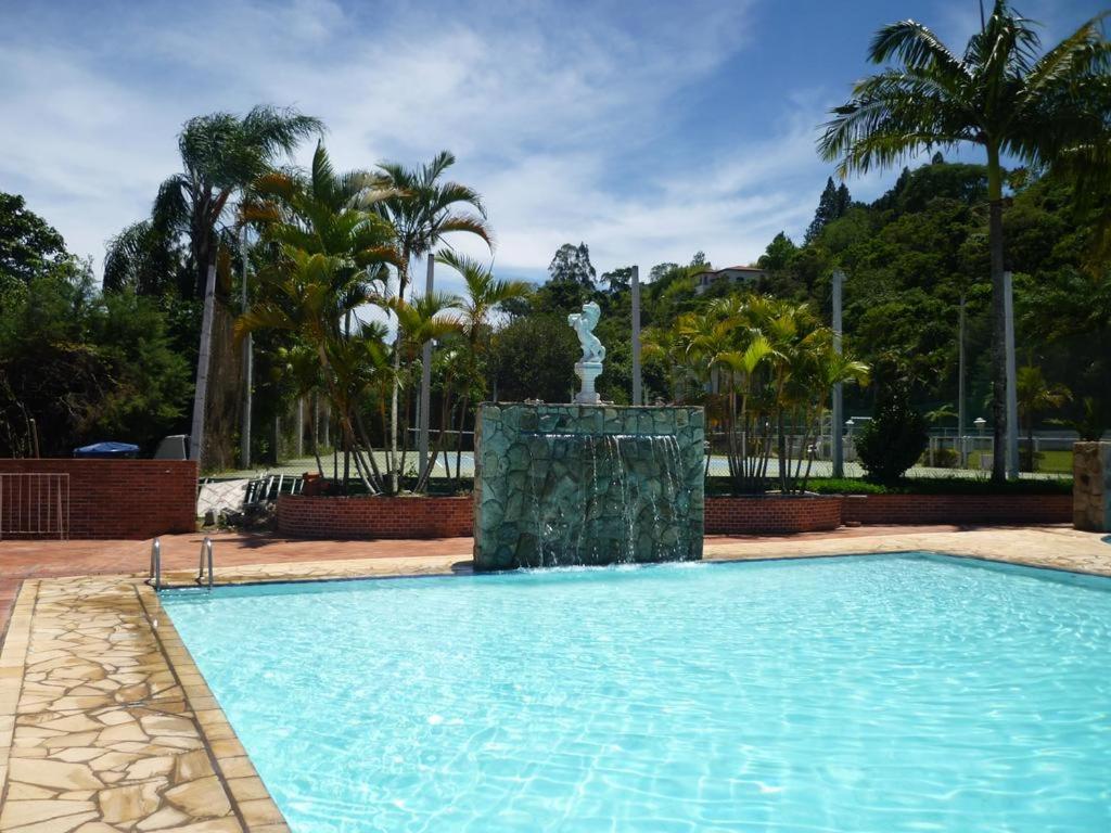 a swimming pool with a fountain in the middle at Flat Cavalinho Branco - Apto 509 in Águas de Lindoia