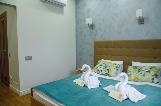 due cigni sono seduti sopra un letto di Sanatory Rassvet a Berdsk