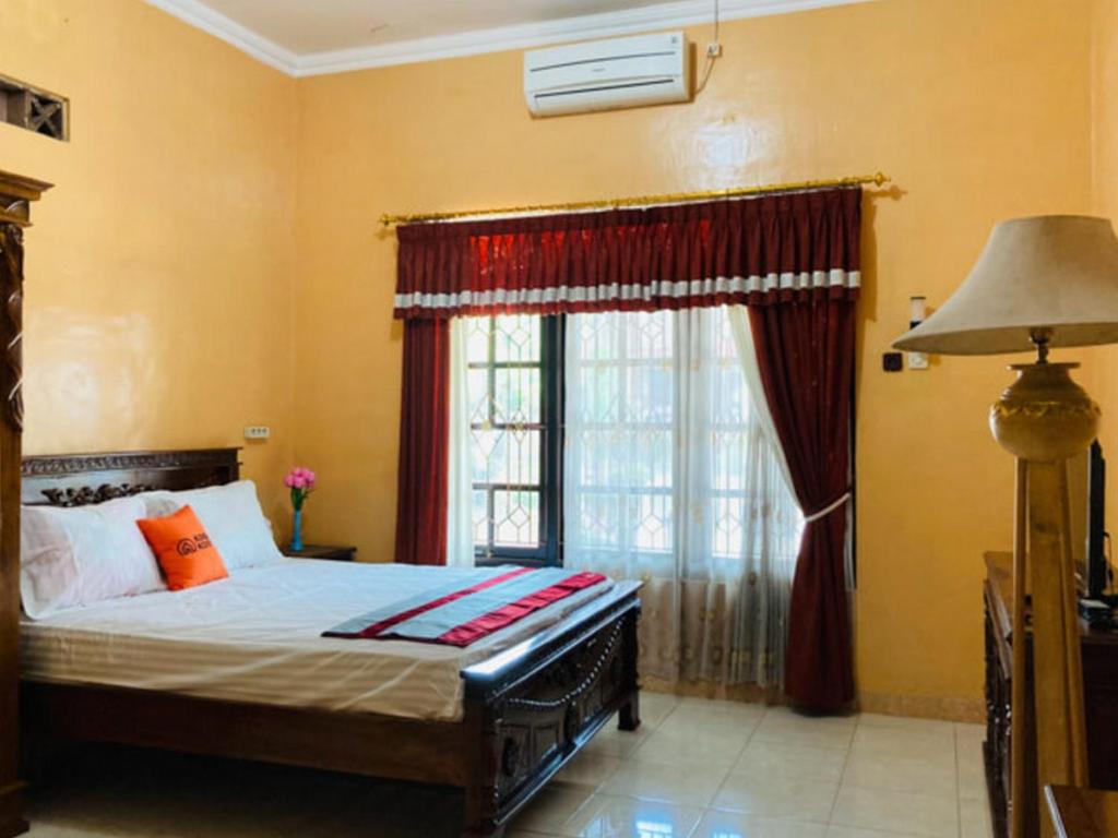 um quarto com uma cama grande e uma janela em KoolKost Syariah @ Jalan Cangkringan Kaliurang em Kentisari