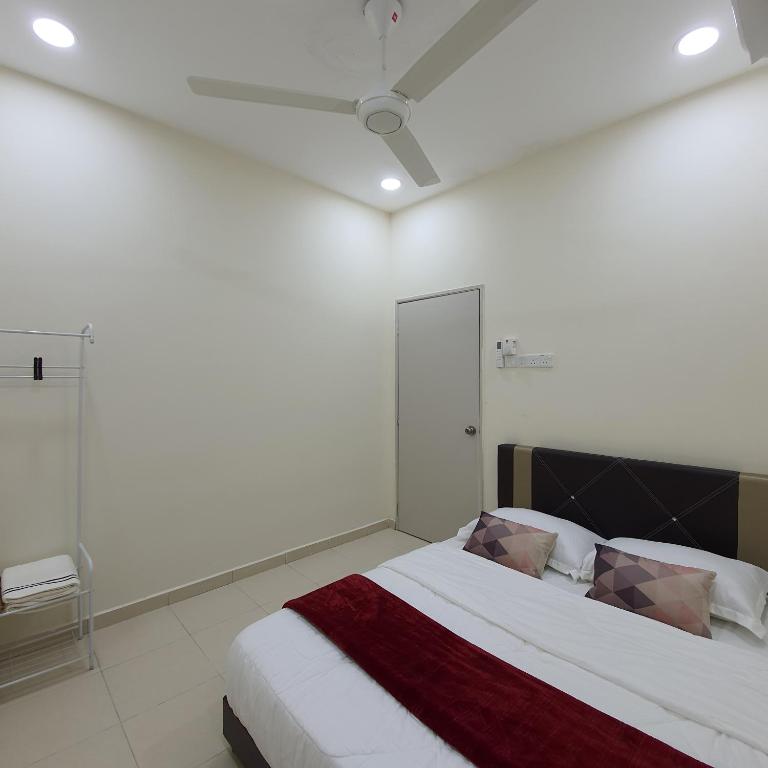 a white bedroom with a bed with a red blanket at Homestay by NAF in Kuantan