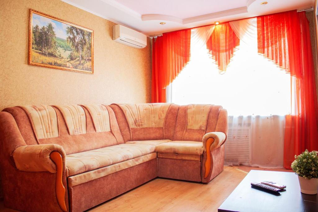 a living room with a couch and a window at Апартаменты "Квартирный вопрос" на 23 Мая 24А in Sterlitamak
