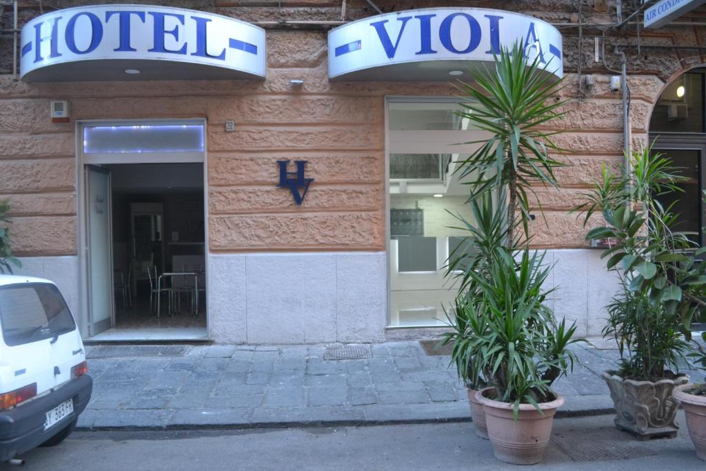 um hotel com vasos de plantas em frente a um edifício em Albergo Viola em Nápoles