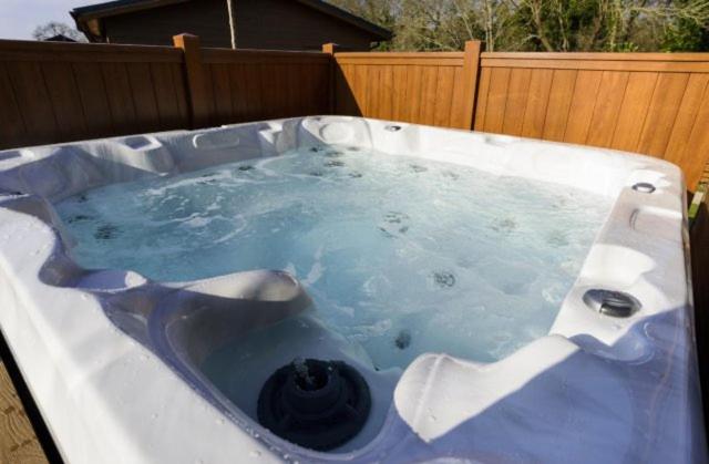 a jacuzzi tub with blue water in it at The Shippen in Great Chatwell