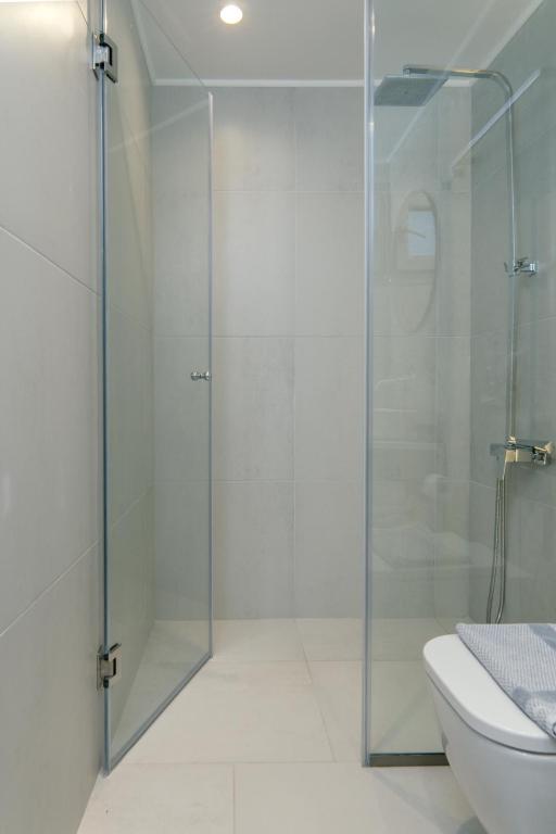 a glass shower in a bathroom with a toilet at Mougre studios in Polychrono
