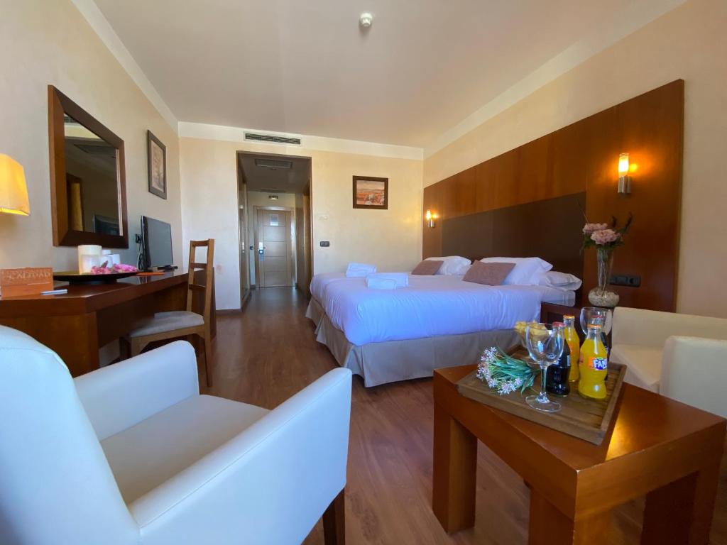 a hotel room with two beds and a living room at Hotel Montera Plaza in Los Barrios