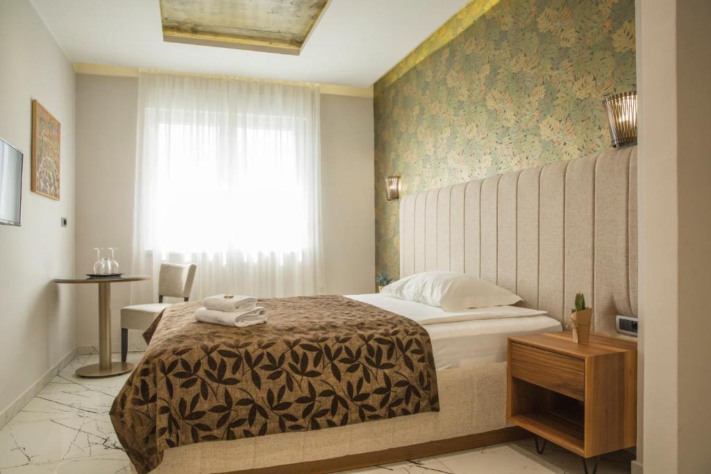 a hotel room with a bed and a window at Garni Boutique Hotel Arta in Novi Sad