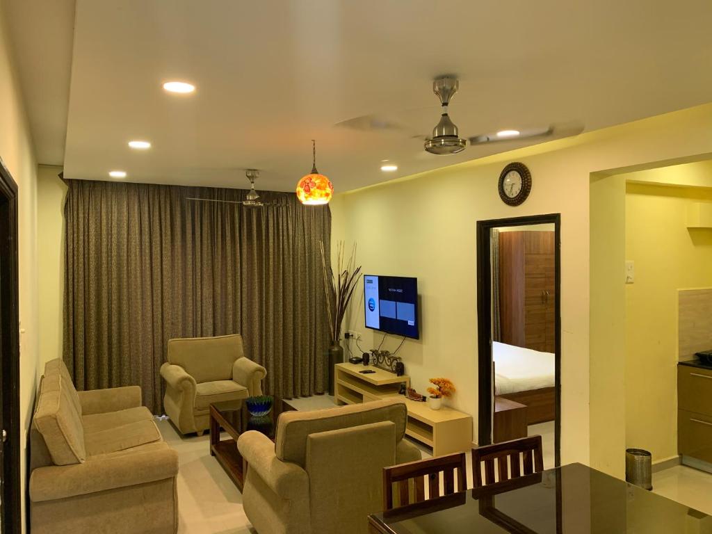 sala de estar con sofá, sillas y espejo en Areia De Goa, Comfort Stay Apartment near Baga Beach en Baga