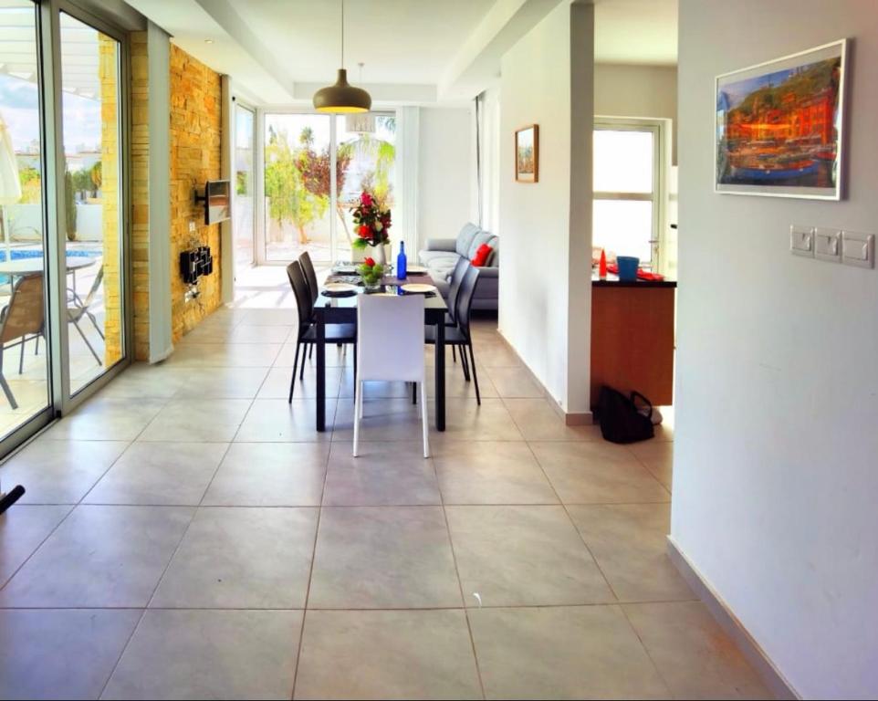 een eetkamer en een woonkamer met een tafel en stoelen bij Milos Lifestyle Villa 17 in Protaras