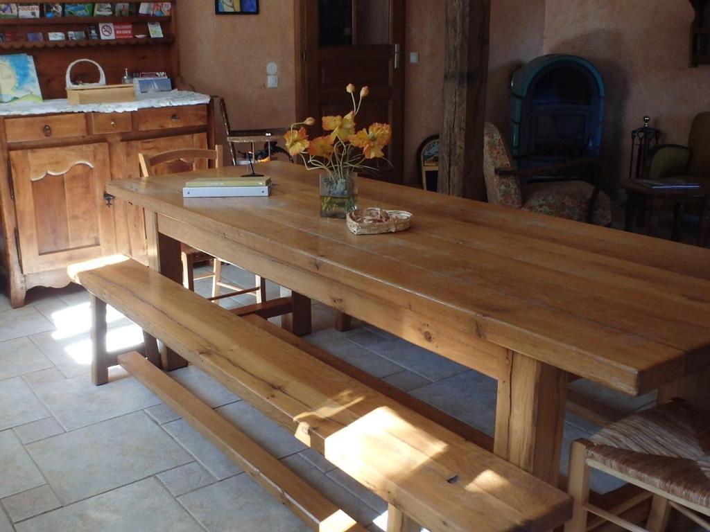 een houten tafel en banken in een keuken bij Le Jardin de Norah in Brulange