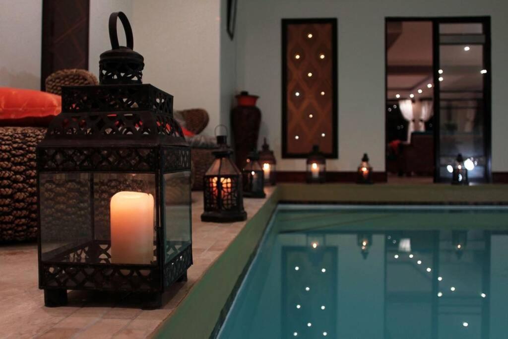 a candle sitting next to a swimming pool with lights at 4 Bedroom Luxury Home with View of the Ocean and Table Mountain in Cape Town