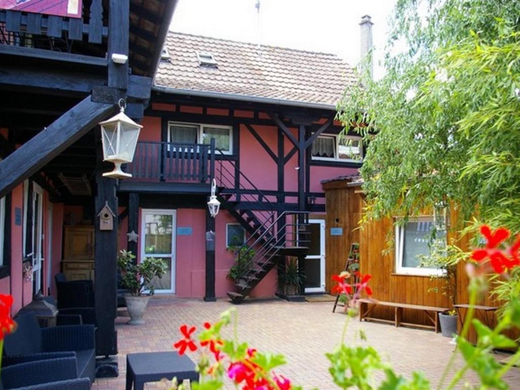 塞勒斯塔的住宿－尚博勒斯迪霍特斯拉多馬恩德斯勒姆帕爾斯酒店，粉红色的房子,庭院里设有楼梯