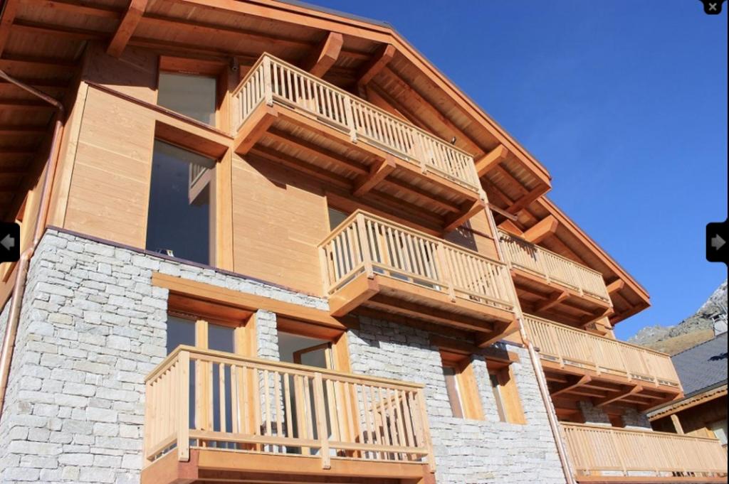 a house with wooden balconies on the side of it at Chalet Le Quartz in Val Thorens