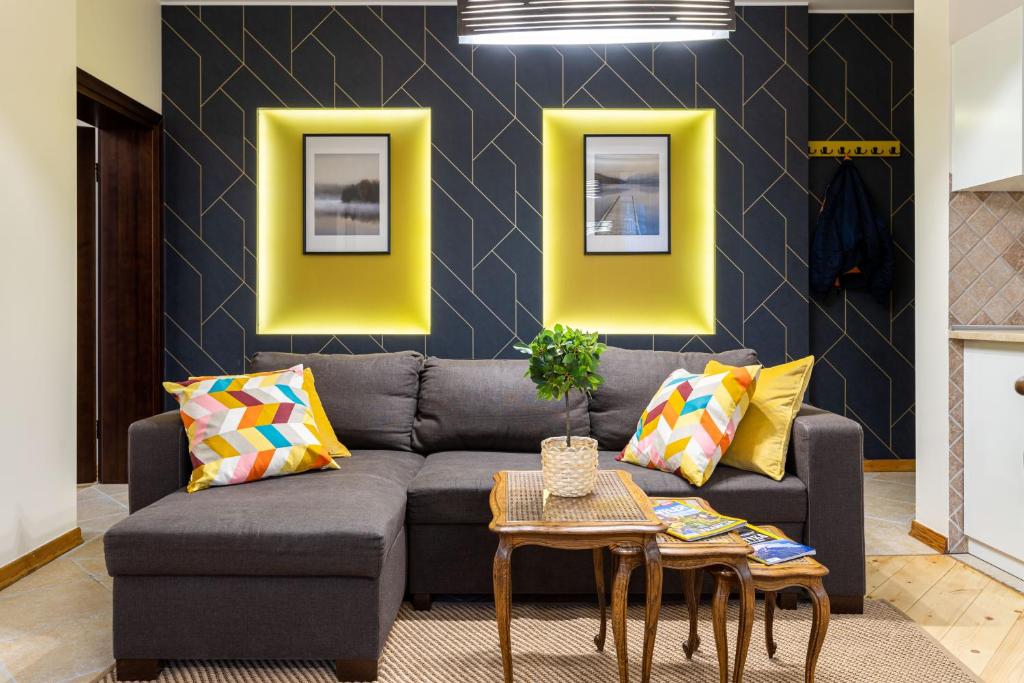 ソポトにあるVictus Apartamenty, Apartament Etnaの黄色をアクセントにしたリビングルーム(グレーのソファ付)