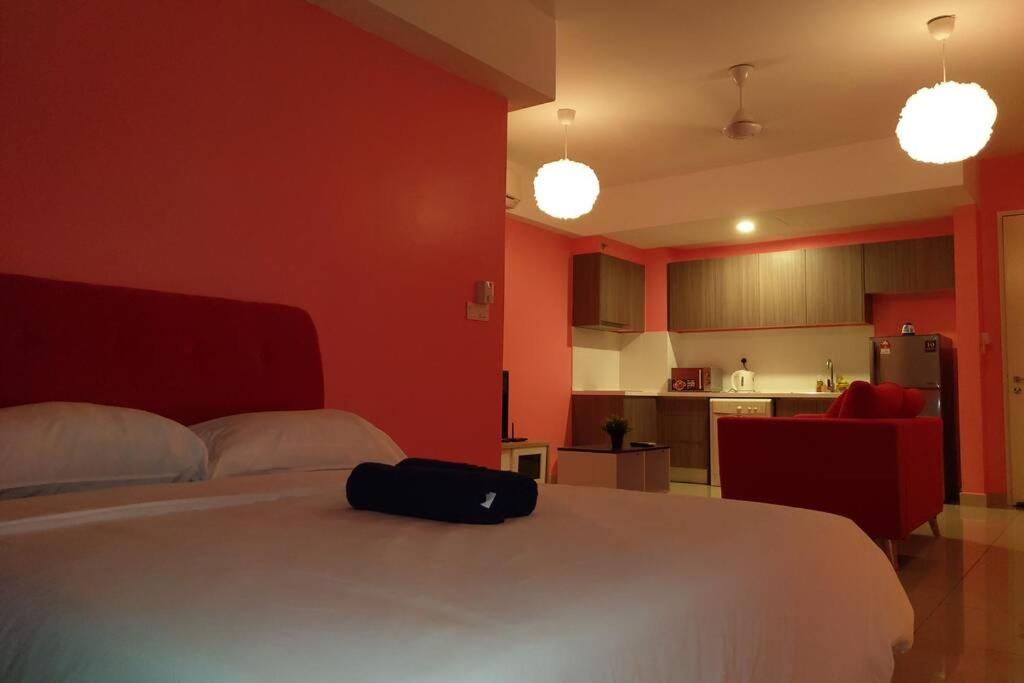 ein Schlafzimmer mit einem weißen Bett mit einer schwarzen Tasche darauf in der Unterkunft HB1611 Lake view studio unit,Hyve, Cyberjaya, Free WiFi, Netflix, Pool, Free Parking, 3039 in Cyberjaya
