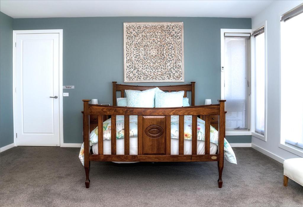 1 dormitorio con cama de madera y paredes azules en Bellarine getaway close to beach, en Curlewis