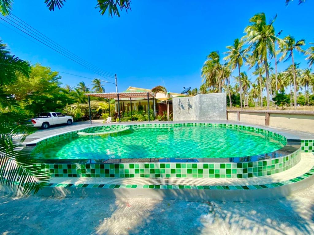 uma piscina num resort com um carro estacionado ao fundo em ศรีสุภาวดีรีสอร์ท-Srisupawadee resort em Prachuap Khiri Khan