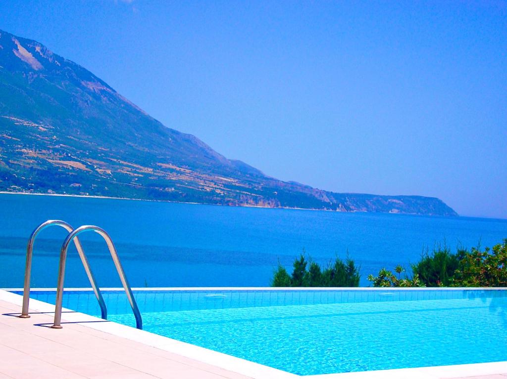 a swimming pool next to a large body of water at Sea View Villa Kefaloniaprivatevillas in Karavadhos