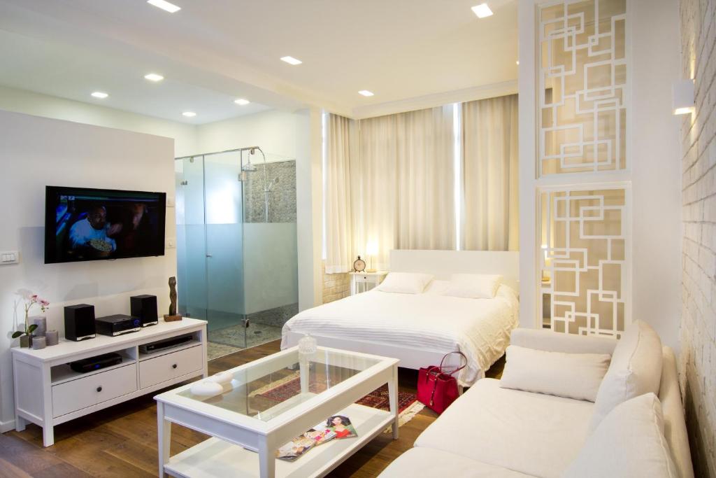 a bedroom with a bed and a tv and a couch at Haifa Luxury Boutique Apartments in Haifa