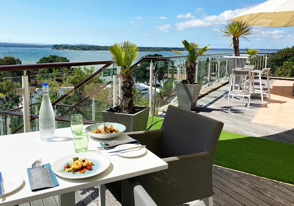 a white table with plates of food on a balcony at Harbour Heights Hotel in Poole