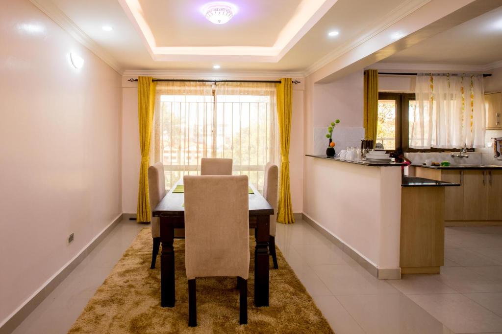 a kitchen and dining room with a table and chairs at RAVIC HOMES NAKURU in Nakuru