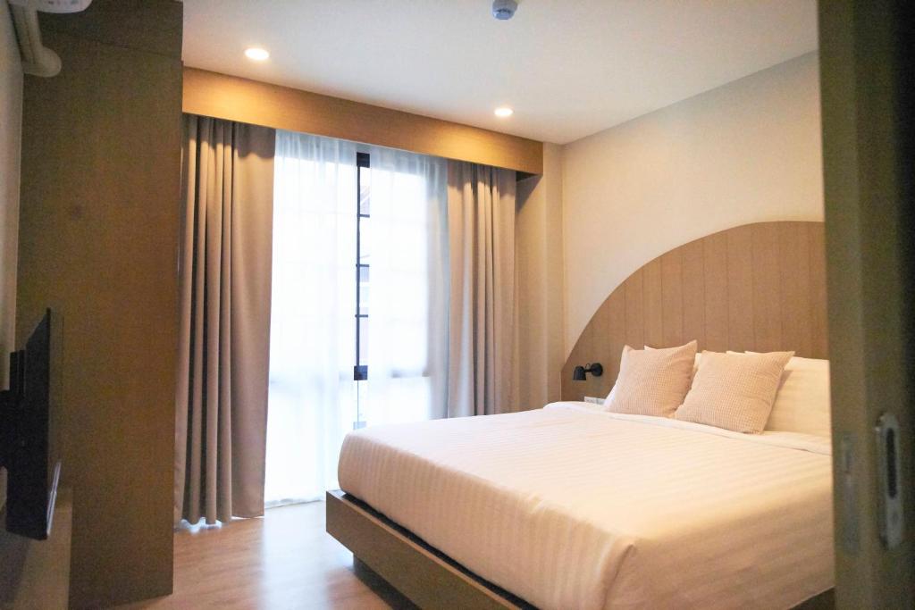 ein Schlafzimmer mit einem großen Bett und einem großen Fenster in der Unterkunft Dream Nimman Apartment in Chiang Mai