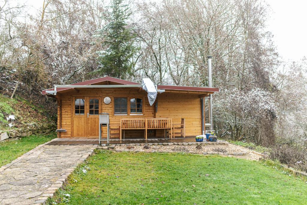 a small wooden cabin with a porch in the woods at Hüttenzauber im Naturpark Altmühltal in Greding