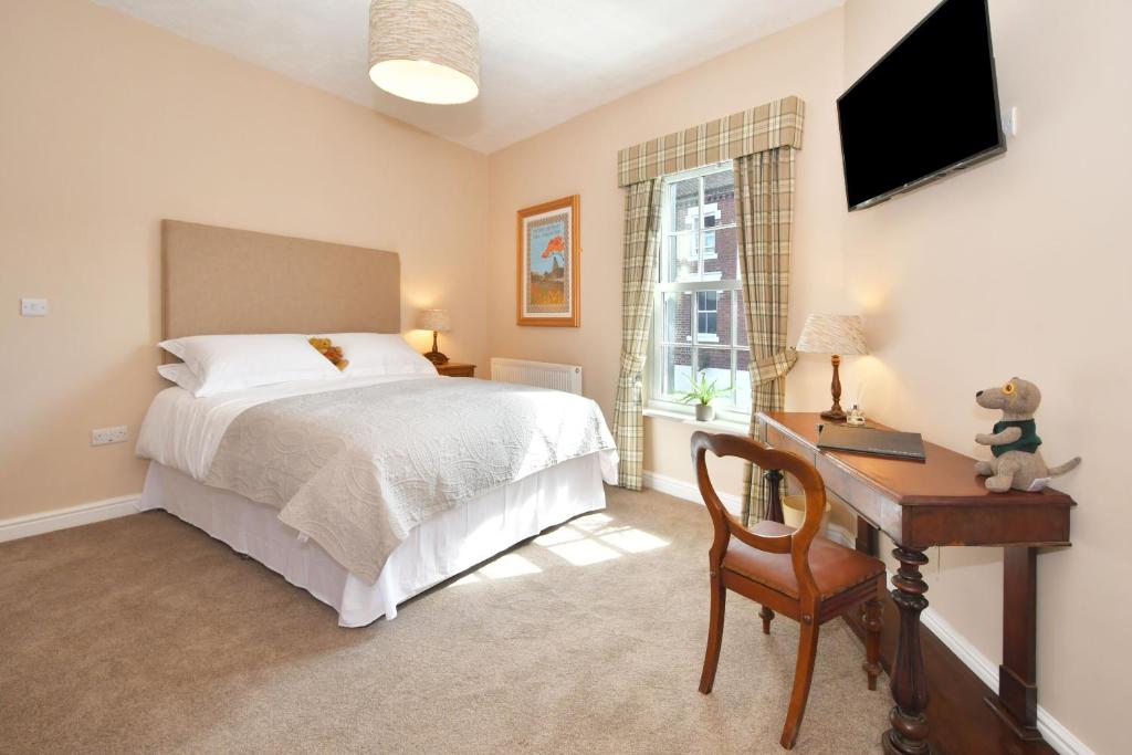 Schlafzimmer mit einem Bett, einem Schreibtisch und einem TV in der Unterkunft The Sutherland Arms in Stoke on Trent