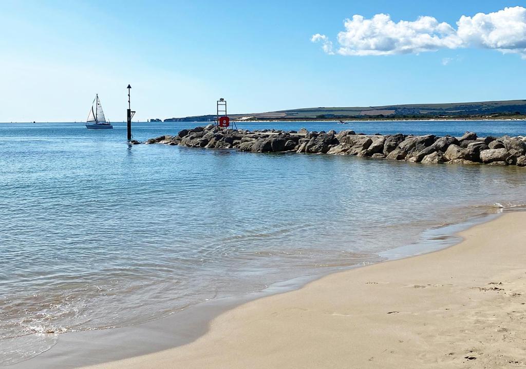 a beach with a boat in the water at Harbour Heights Hotel in Poole