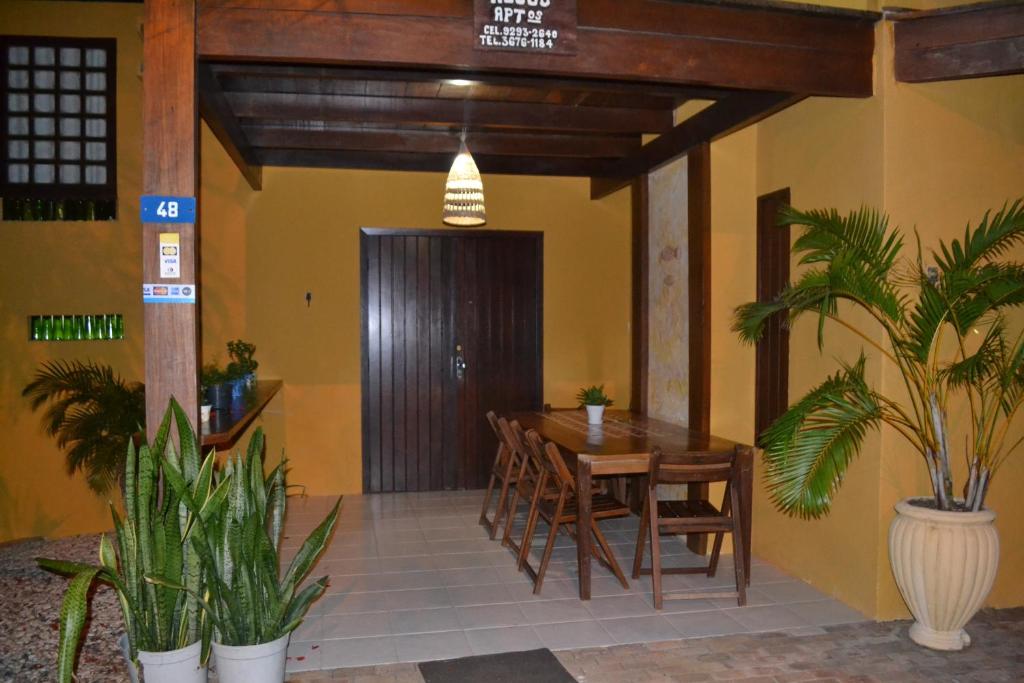 a dining room with a table and chairs and plants at Pousada Peixe Espada in Praia do Forte