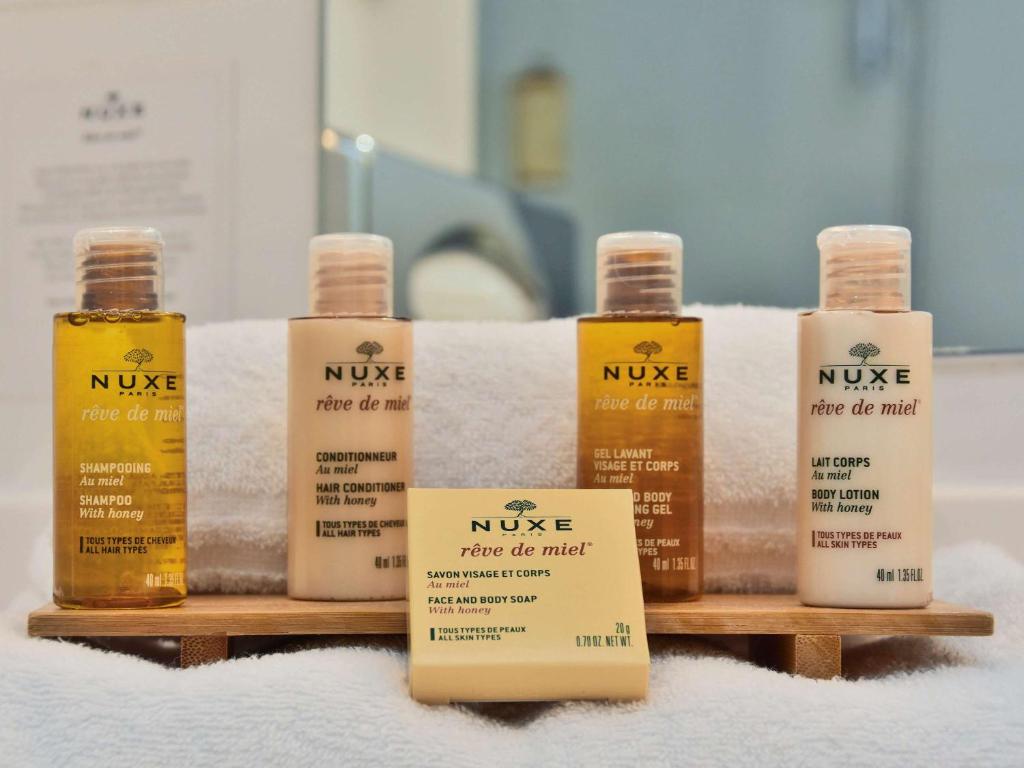 a group of four bottles of nue hair products on a shelf at Mercure Granville Le Grand Large in Granville