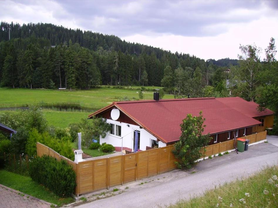 una casa con techo rojo y valla en Apartment Erlauf - Ursprung, - 6 Personen, Outdoorsauna mit Bachzugang, en Mitterbach