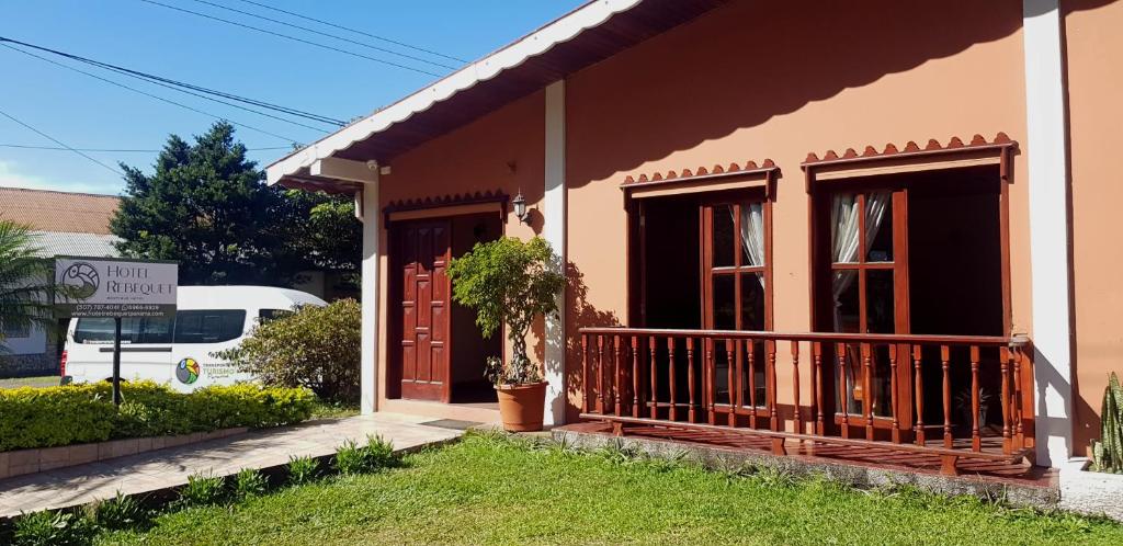 een klein huis met een veranda en een bord bij Hotel Rebequet in Boquete