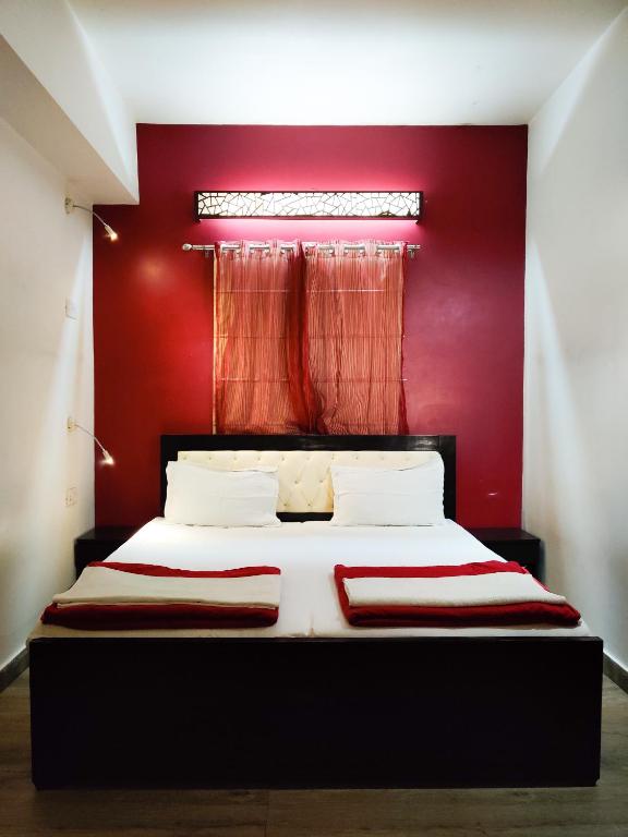 a red bedroom with a bed with a red wall at Joey's Hostel Delhi - 20 mins from Railway Station in New Delhi