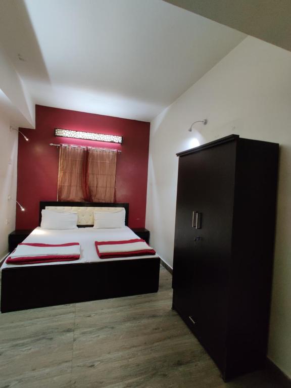 a bedroom with a bed and a red wall at Joey's Hostel Delhi - 20 mins from Railway Station in New Delhi