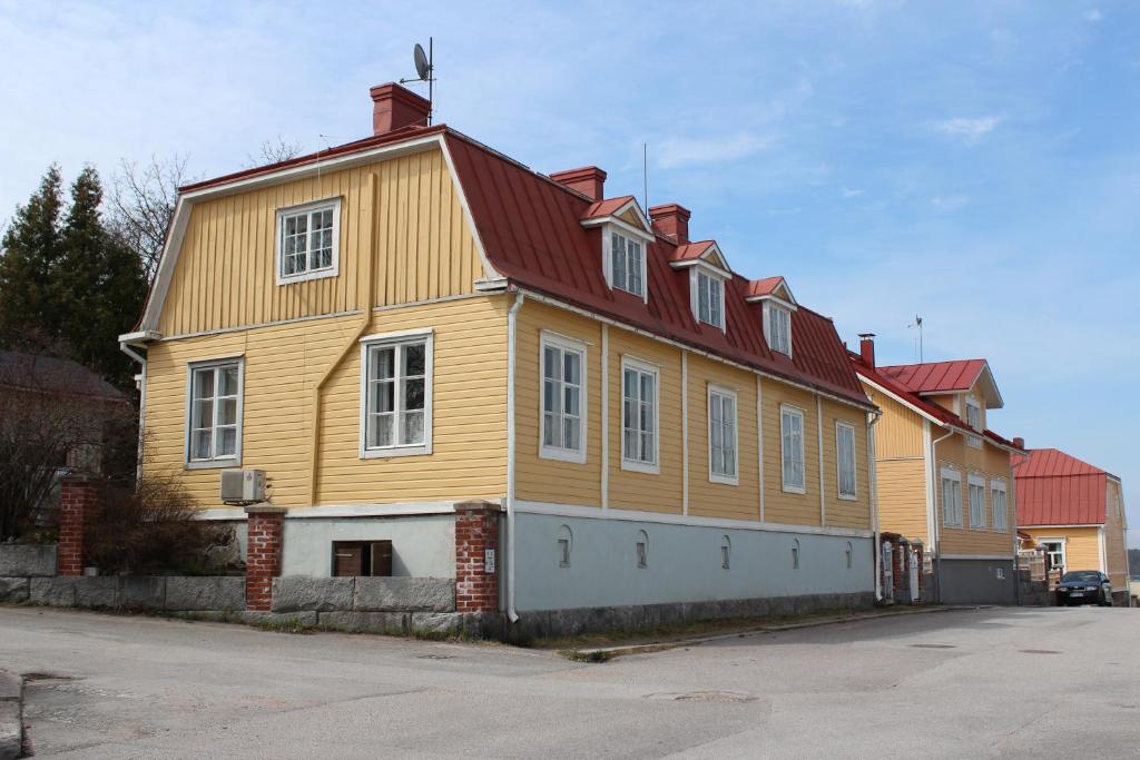 une grande maison jaune avec un toit rouge dans l'établissement Slottsbädden, à Tammisaari