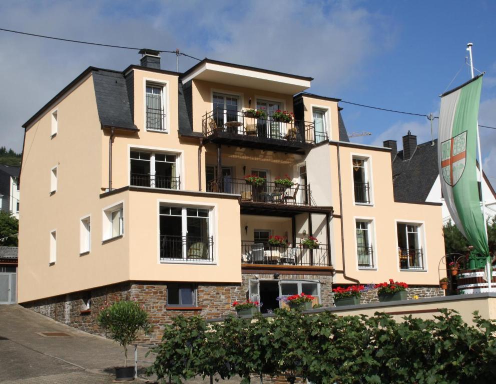 a building with balconies and a flag in front of it at Weingut Goeres in Briedel