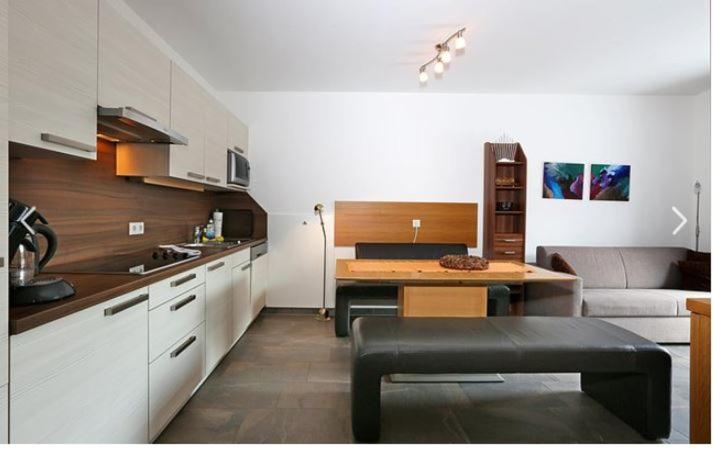 a kitchen and living room with a table and a couch at Deluxe Apartment SCHRABERGER TOP 6 in Schladming