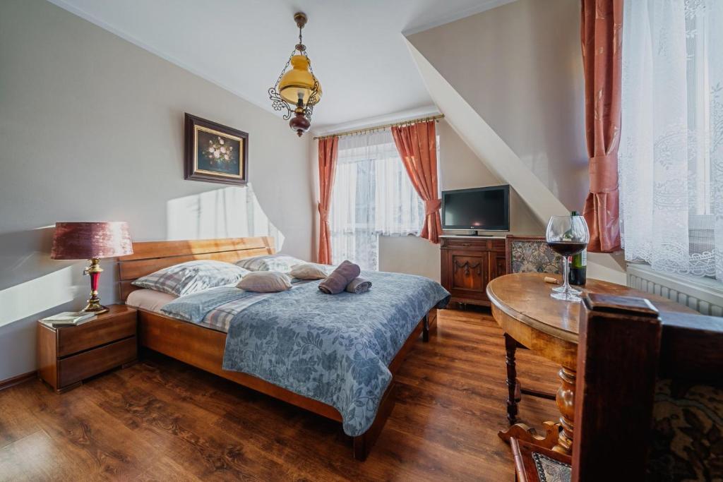 a bedroom with a bed, desk, chair, and lamp at Villa Nawrot in Zakopane