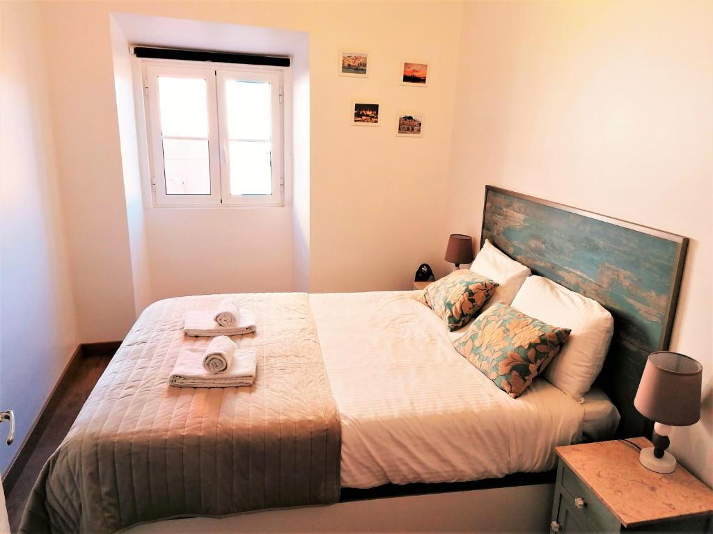 a bedroom with a bed with two towels on it at Apartment in the Castle of S. Jorge in Lisbon