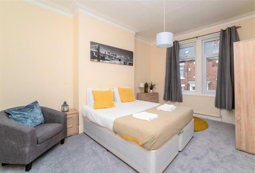 a bedroom with a bed and a chair at Eglesfield 3 Bedroom South Shields in South Shields