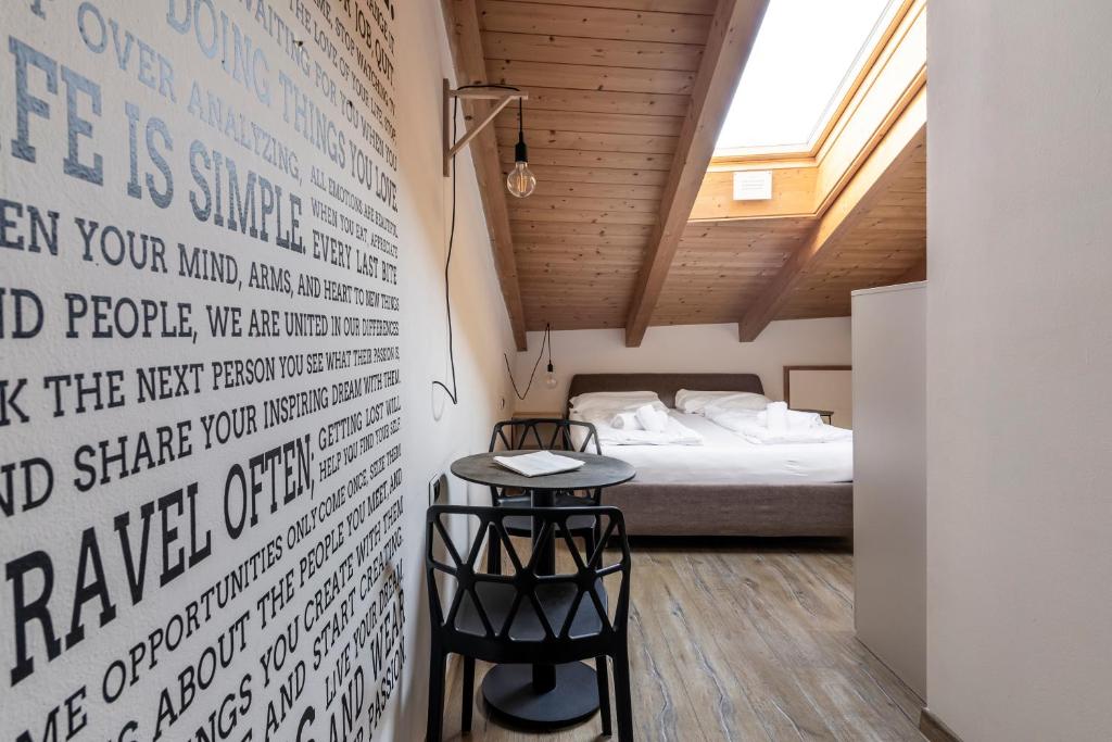 ボルツァーノにあるStay COOPER l Goethe Guesthouseのベッドと小さなテーブル付きの小さな部屋
