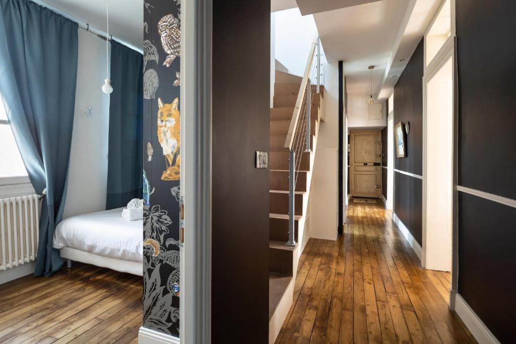 pasillo con cama y escalera en una habitación en Les Trois Rois - Duplex Familial de Charme en cœur de ville en Rennes
