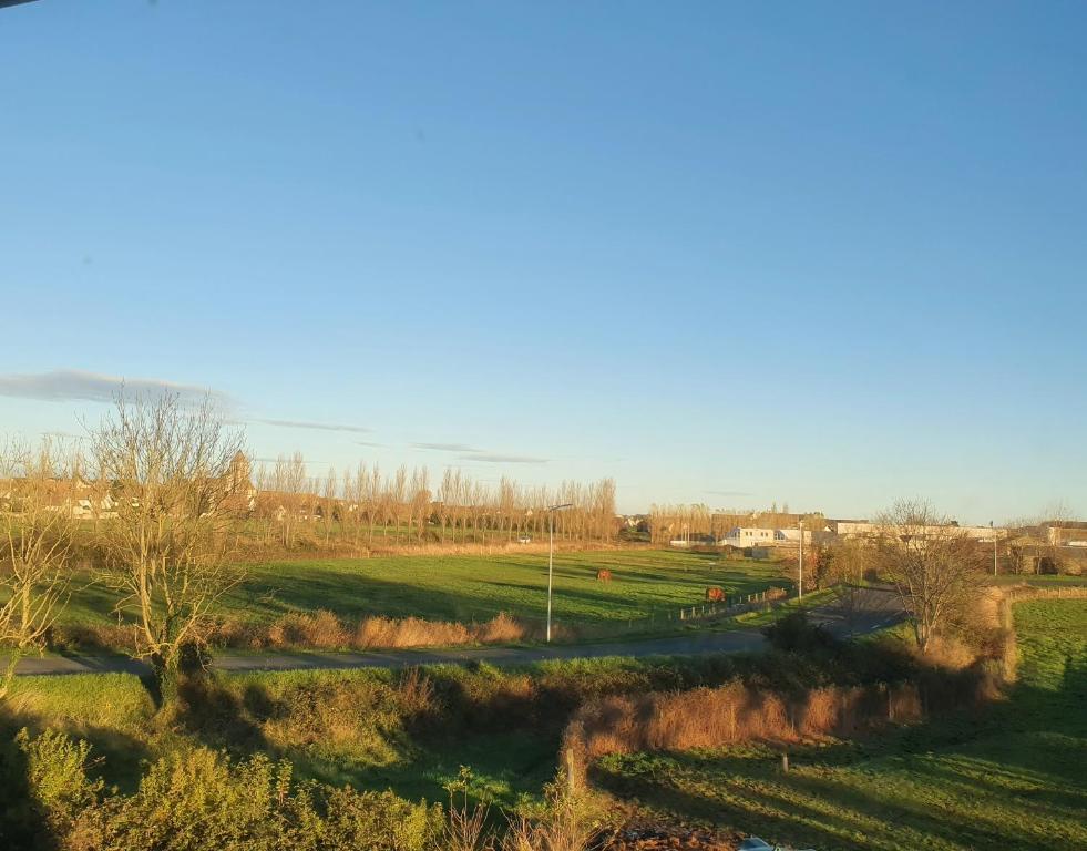 a view of a field with trees and a road at B&B HOTEL Ouistreham in Ouistreham