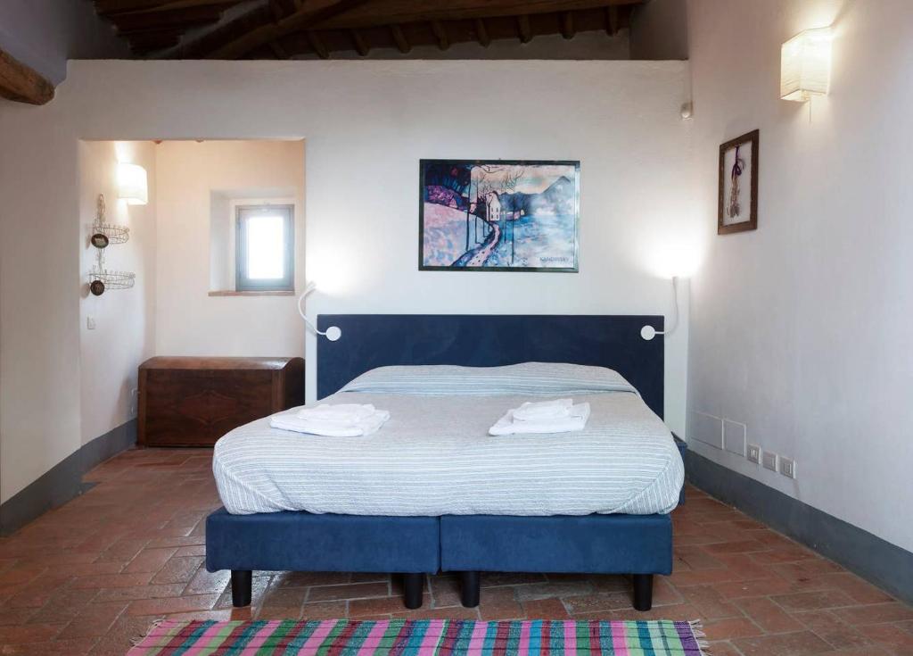 a bedroom with a blue bed with two towels on it at Poderi in Chianti in Tavarnelle in Val di Pesa