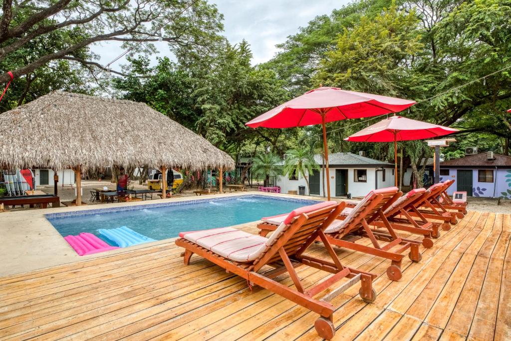 a patio area with chairs, umbrellas, and tables at Selina Tamarindo in Tamarindo