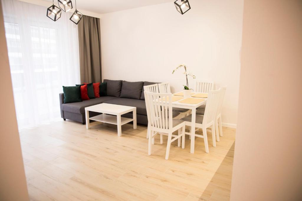 een woonkamer met een bank en een tafel en stoelen bij Apartament Royal Place I Jurowiecka 17 in Białystok
